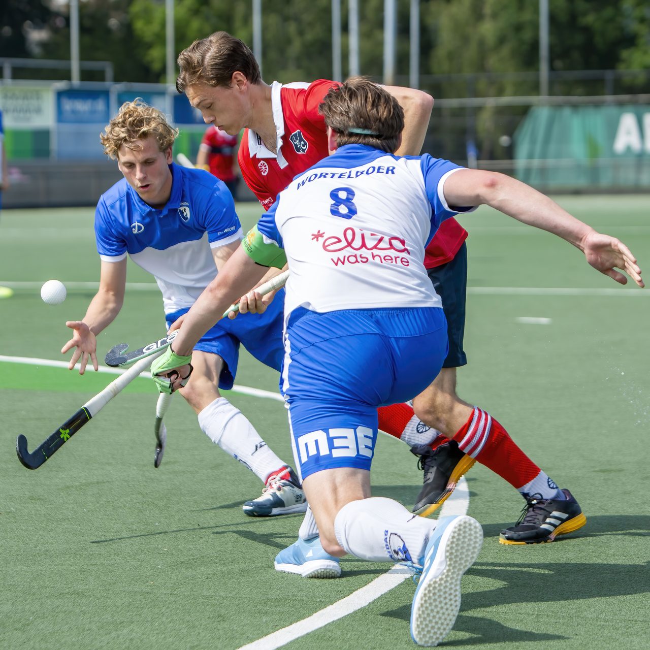 Drie spelers vechten om een bal die door de lucht vliegt