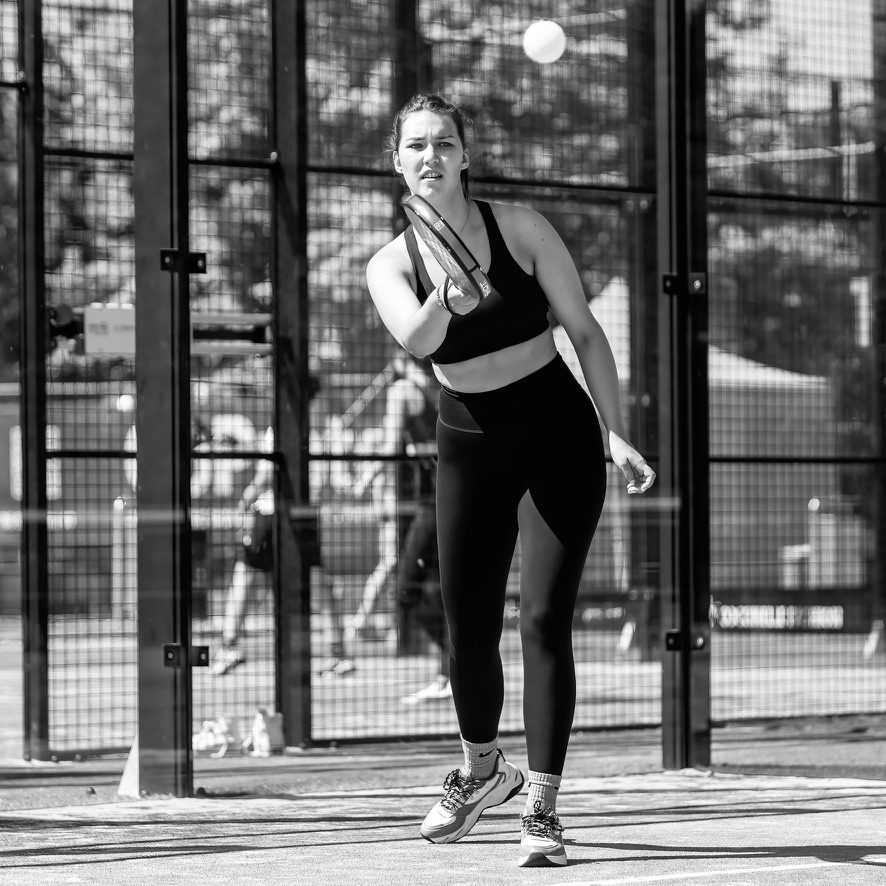 Padelspeelster na een slag, in zwart-wit